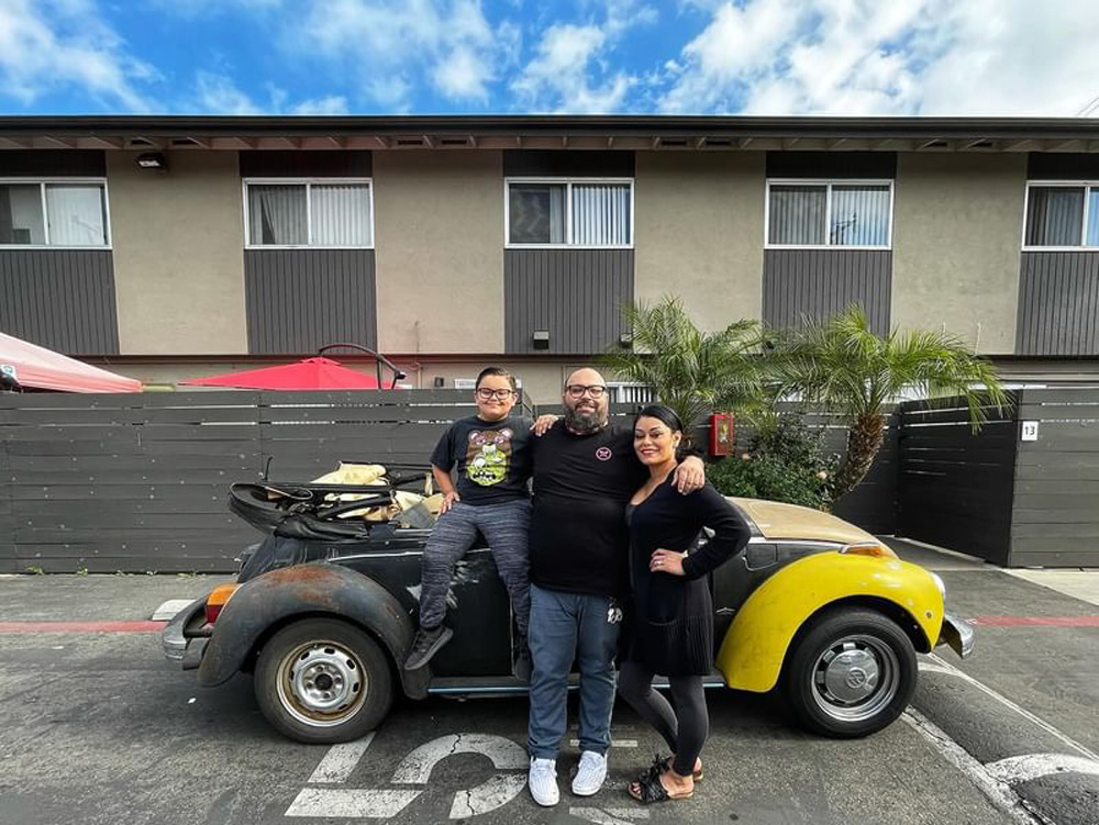 VW Family stands beside their ride