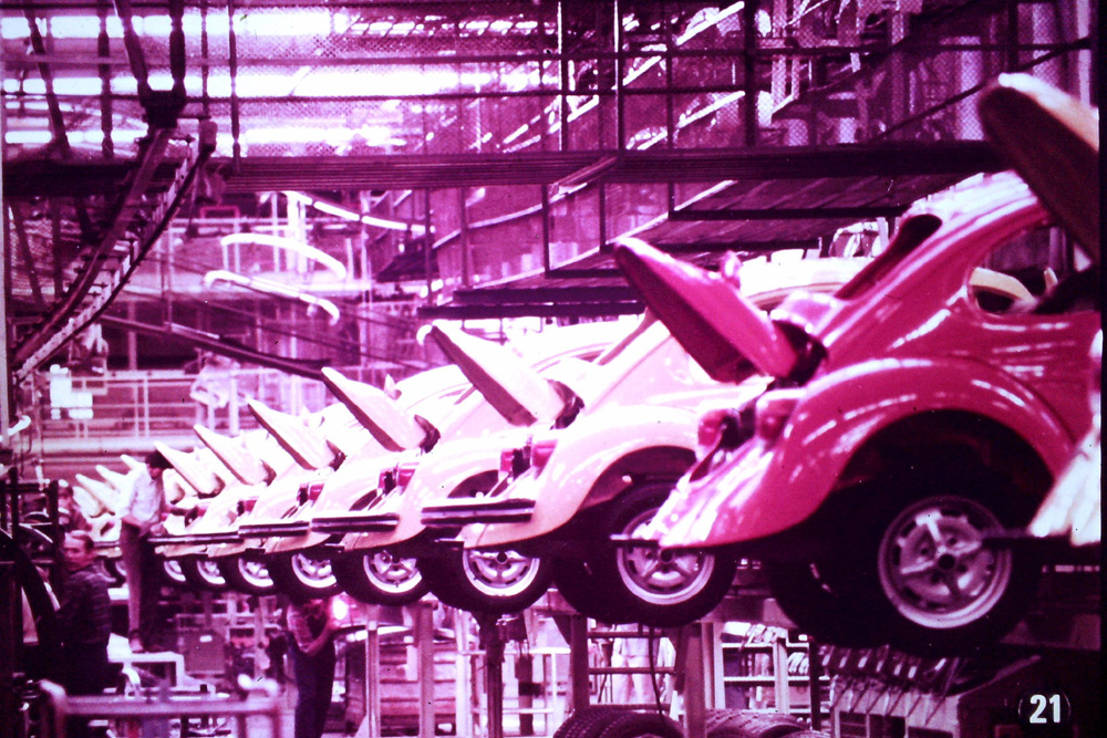 Super Beetles with their deck lids open wait for a final engine check